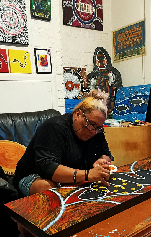 Artist Jude Jarrett painting in her home